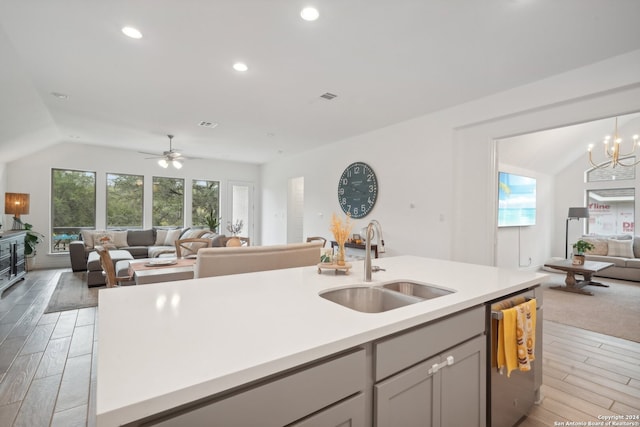 kitchen with lofted ceiling, dishwasher, light hardwood / wood-style flooring, sink, and ceiling fan with notable chandelier