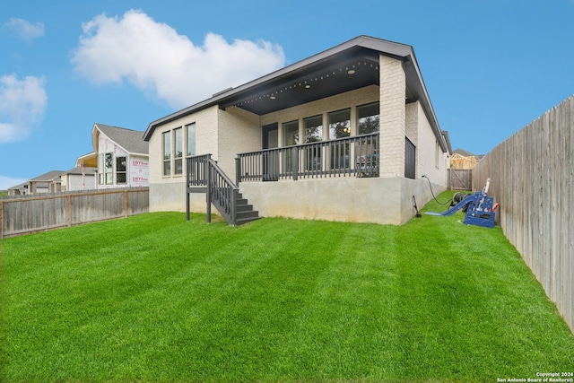 rear view of house featuring a lawn