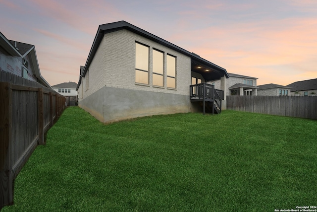 back house at dusk with a lawn