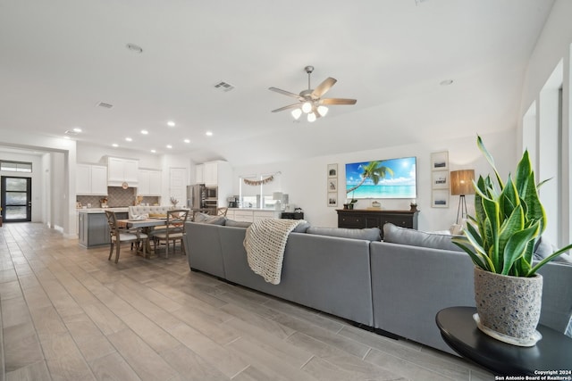 living room featuring light hardwood / wood-style floors and ceiling fan