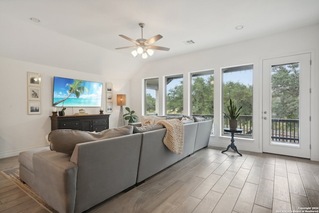 living room with lofted ceiling, hardwood / wood-style flooring, ceiling fan, and a wealth of natural light