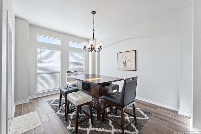 dining space with a notable chandelier and dark hardwood / wood-style flooring