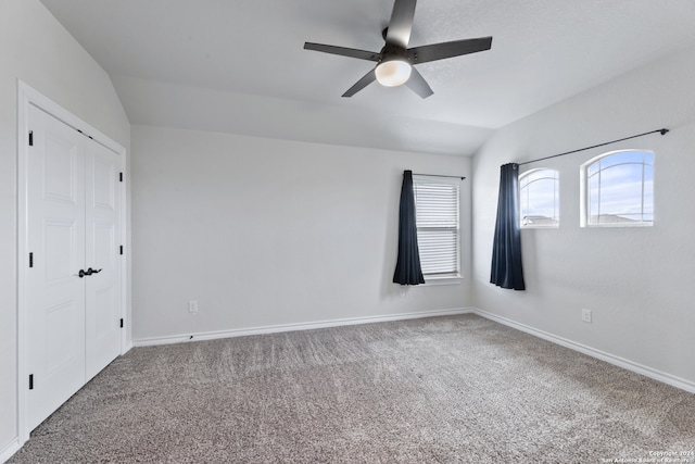 carpeted empty room with ceiling fan and vaulted ceiling