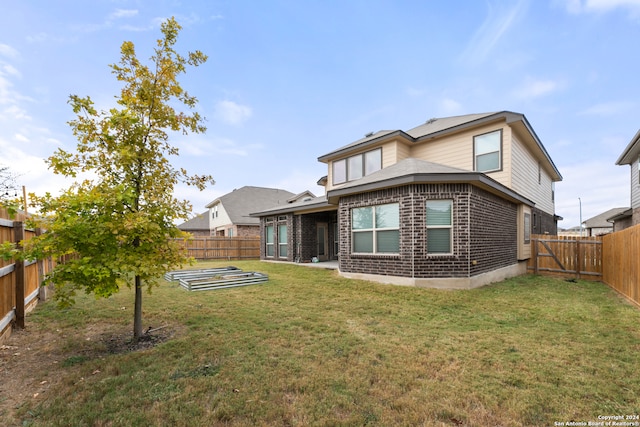 rear view of house featuring a yard and a patio