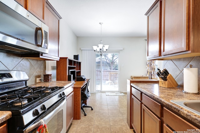 kitchen with appliances with stainless steel finishes, light tile patterned flooring, pendant lighting, a notable chandelier, and decorative backsplash