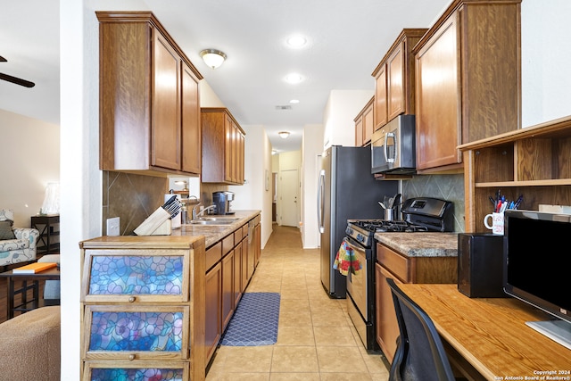 kitchen with tasteful backsplash, sink, gas stove, ceiling fan, and light tile patterned floors