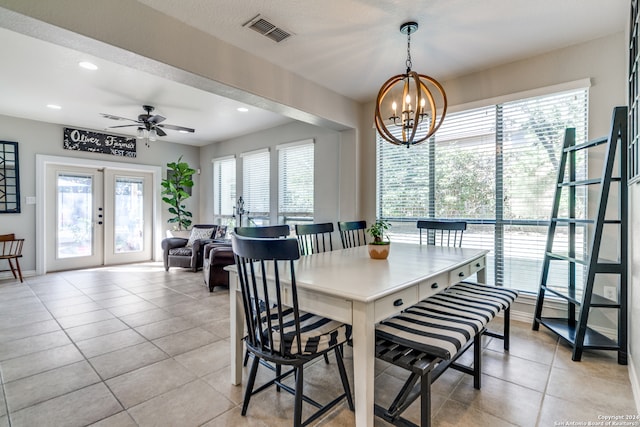 dining area with french doors, light tile patterned flooring, and ceiling fan with notable chandelier