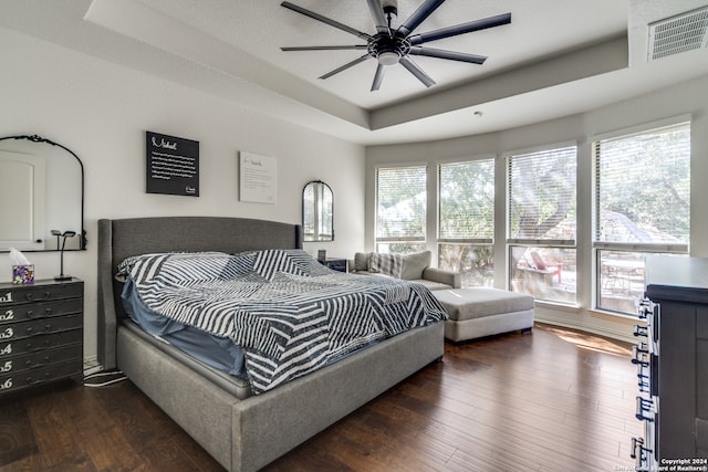 bedroom with ceiling fan, multiple windows, and dark hardwood / wood-style flooring