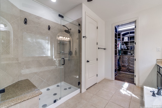 bathroom with vanity, a shower with shower door, and tile patterned flooring