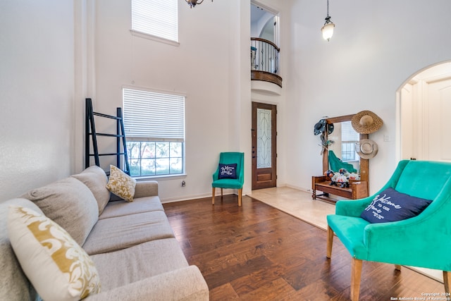 living room with dark wood-type flooring and a towering ceiling