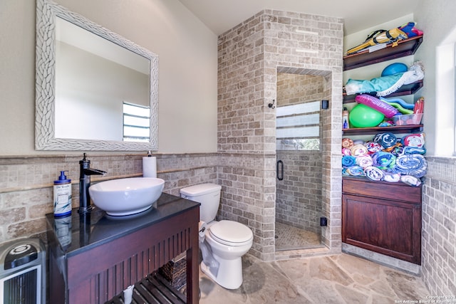 bathroom featuring vanity, walk in shower, toilet, and tile walls