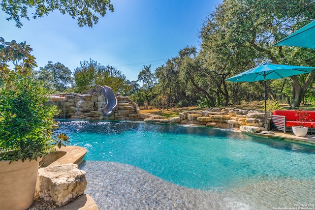 view of pool with a water slide and pool water feature