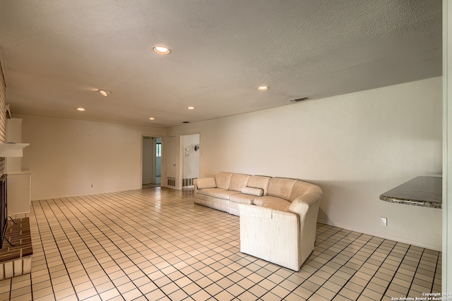 unfurnished living room featuring a textured ceiling, light tile patterned floors, and a fireplace