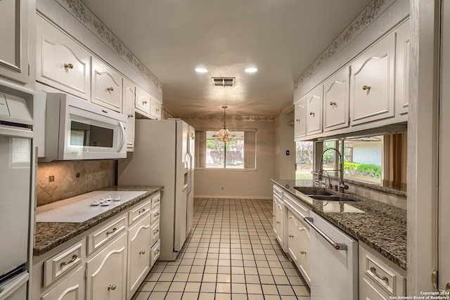 kitchen with sink, light tile patterned flooring, decorative light fixtures, white cabinets, and white appliances