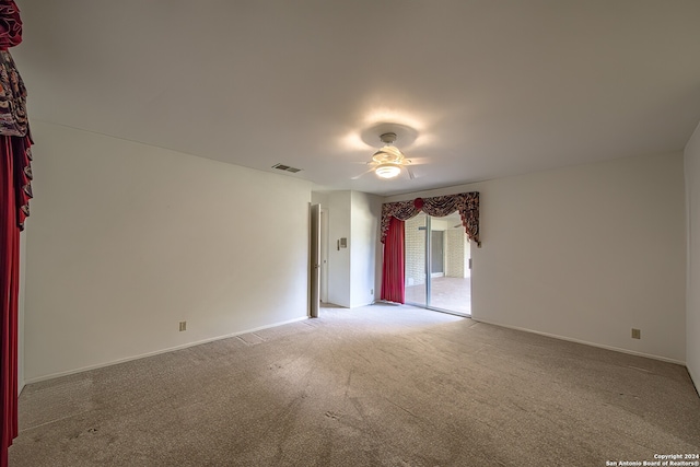 carpeted spare room with ceiling fan