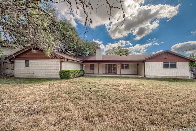 rear view of property featuring a yard