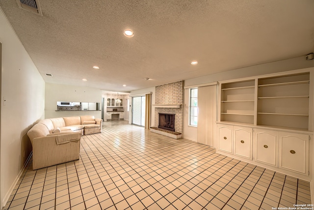 unfurnished living room with a textured ceiling and a brick fireplace