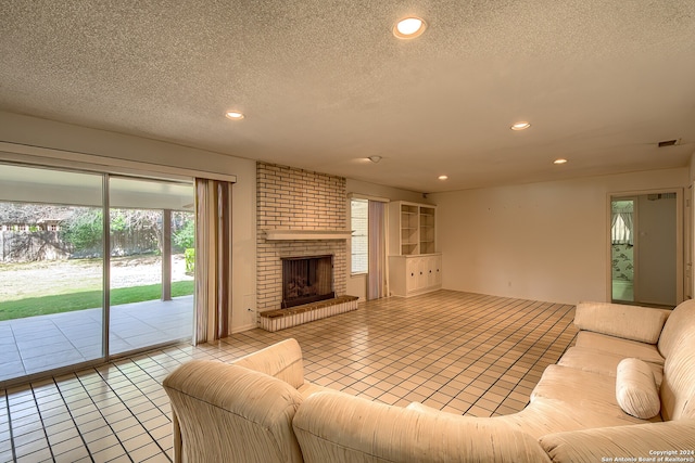 tiled living room with a textured ceiling and a fireplace