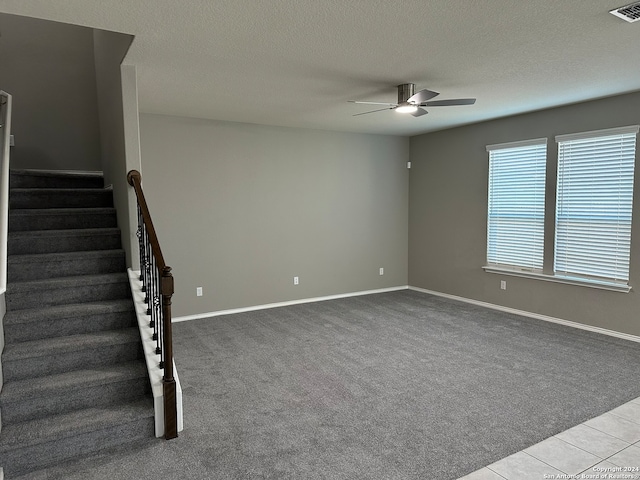 carpeted empty room with a textured ceiling and ceiling fan