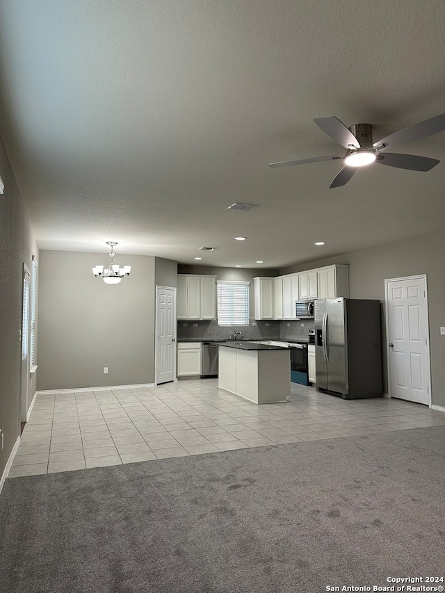 kitchen featuring light carpet, hanging light fixtures, stainless steel appliances, a center island, and white cabinets