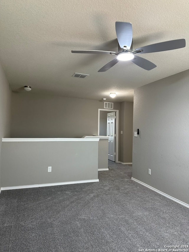 carpeted empty room featuring a textured ceiling and ceiling fan