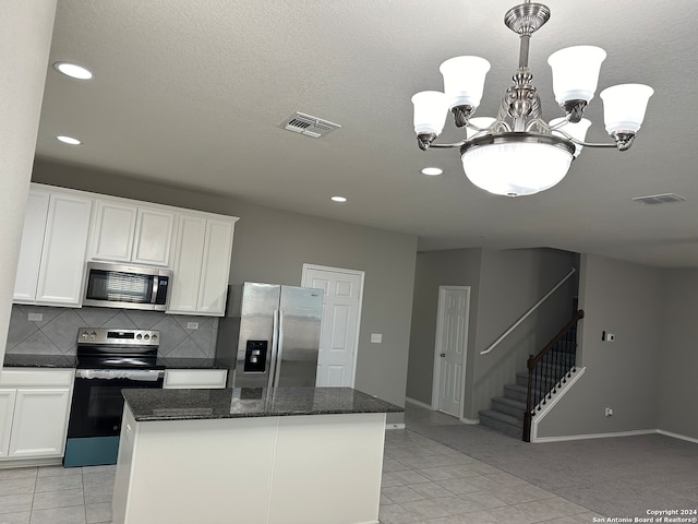 kitchen featuring a center island, appliances with stainless steel finishes, pendant lighting, and white cabinetry