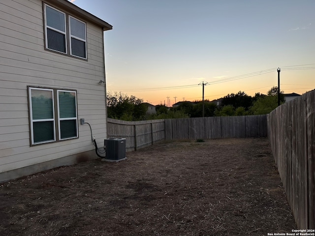 yard at dusk featuring central air condition unit