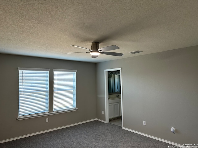 carpeted empty room with a textured ceiling and ceiling fan