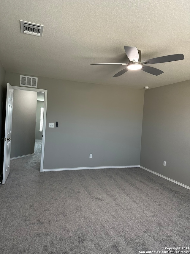 unfurnished room with ceiling fan, carpet, and a textured ceiling