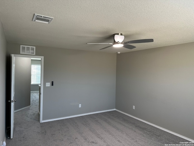 carpeted empty room with a textured ceiling and ceiling fan