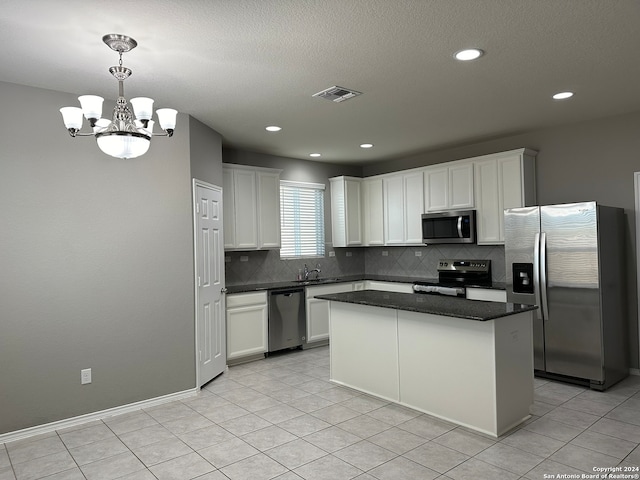 kitchen with sink, a center island, white cabinets, pendant lighting, and appliances with stainless steel finishes