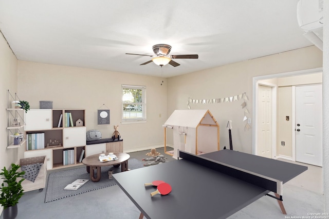 playroom featuring ceiling fan and concrete flooring