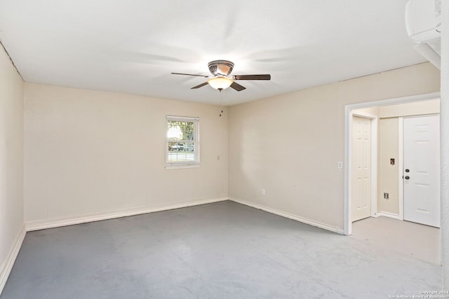 spare room with ceiling fan and concrete floors