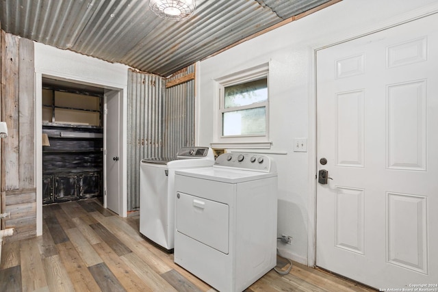 washroom featuring washing machine and clothes dryer and light hardwood / wood-style flooring