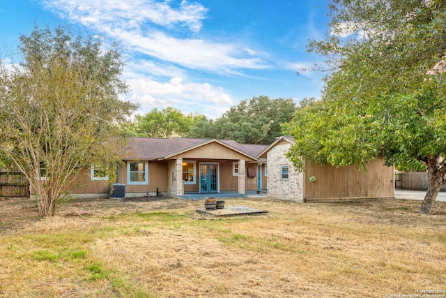 rear view of property with a yard and central AC unit