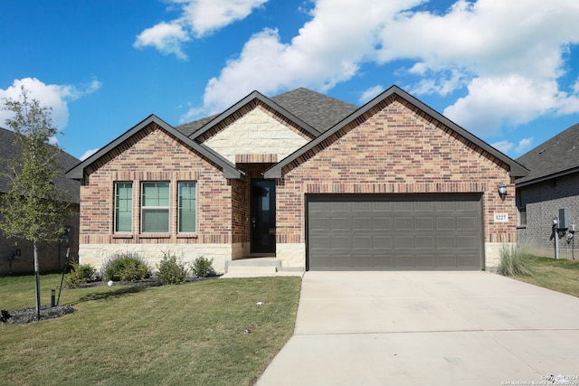 view of front of property featuring a garage and a front lawn