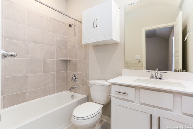 full bathroom featuring vanity, toilet, tiled shower / bath combo, and vaulted ceiling