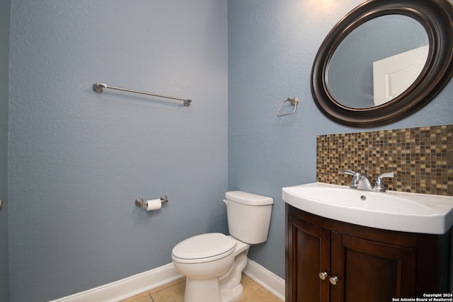 bathroom featuring vanity, toilet, tile patterned floors, and decorative backsplash