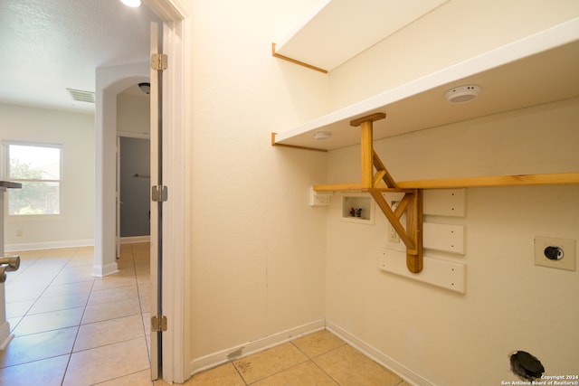 clothes washing area with hookup for a washing machine, light tile patterned floors, and hookup for an electric dryer