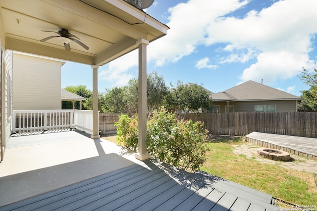 wooden terrace featuring a patio, a fire pit, a lawn, and ceiling fan