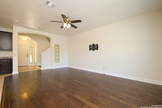 unfurnished living room featuring ceiling fan, built in features, and light hardwood / wood-style flooring