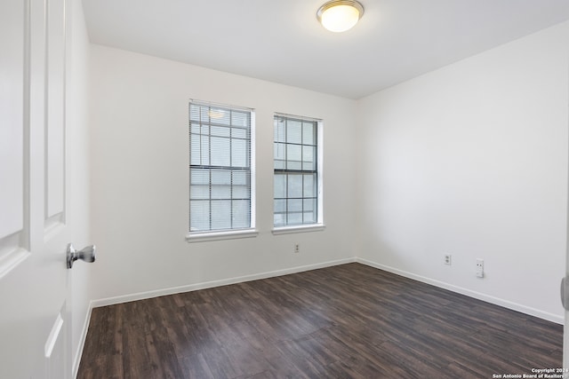 spare room with dark wood-type flooring