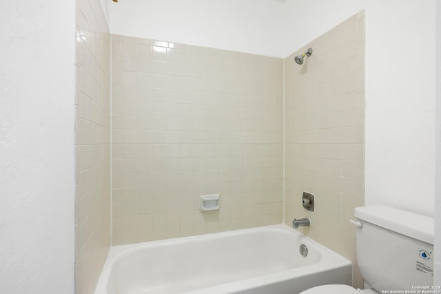 bathroom featuring tiled shower / bath and toilet