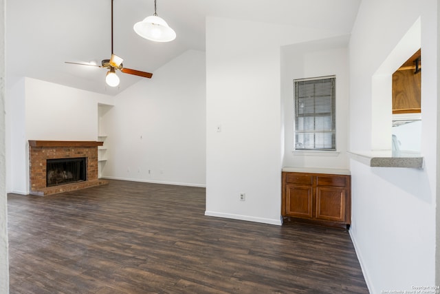 unfurnished living room with vaulted ceiling, ceiling fan, a fireplace, and dark hardwood / wood-style flooring