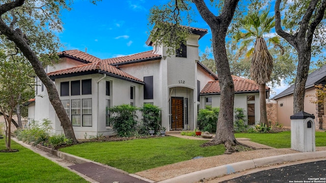 mediterranean / spanish-style house with a front lawn