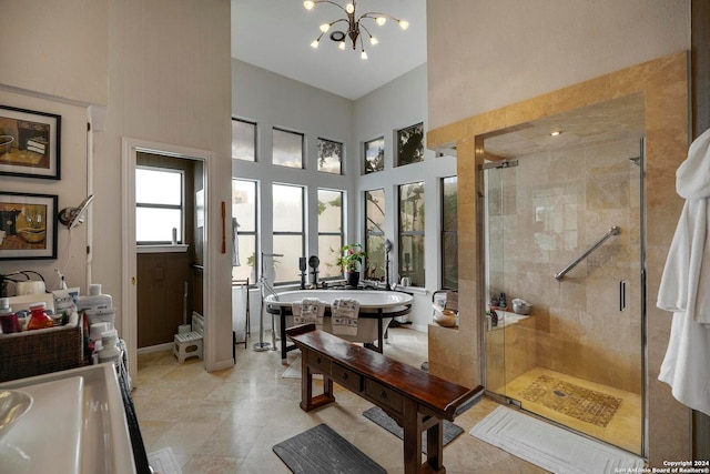 bathroom with a notable chandelier, a shower with shower door, and a towering ceiling