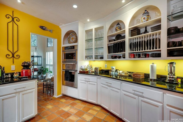 kitchen featuring white cabinetry, double oven, a textured ceiling, and pendant lighting