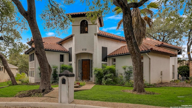 mediterranean / spanish house with a front lawn