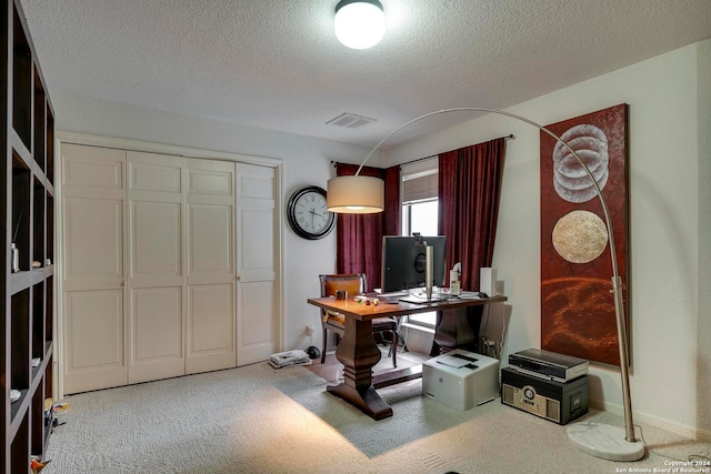 office area with carpet floors and a textured ceiling