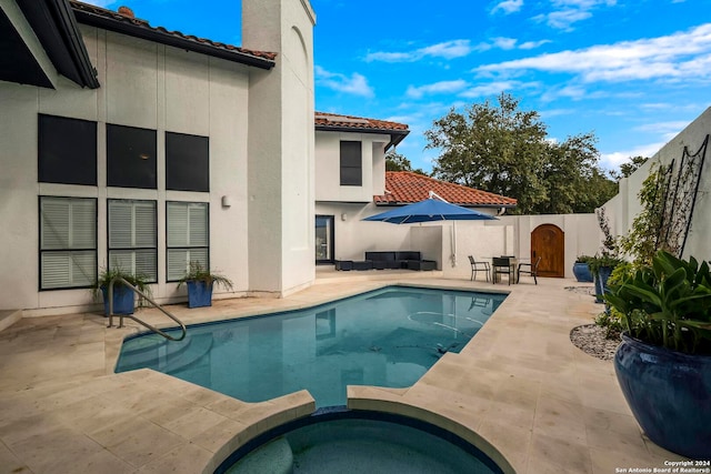 view of swimming pool with a patio and an in ground hot tub